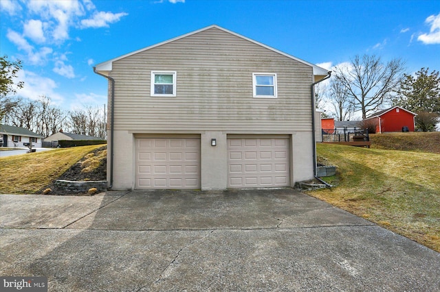 view of property exterior featuring a lawn, concrete driveway, a garage, and stucco siding