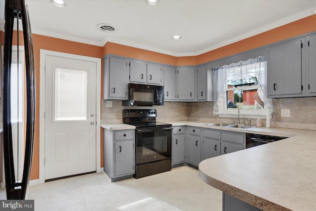 kitchen with visible vents, gray cabinets, black appliances, and a sink