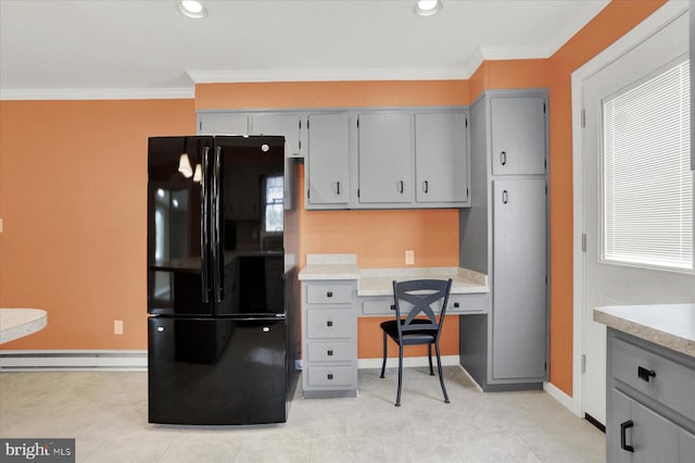 kitchen with light countertops, gray cabinetry, crown molding, and freestanding refrigerator