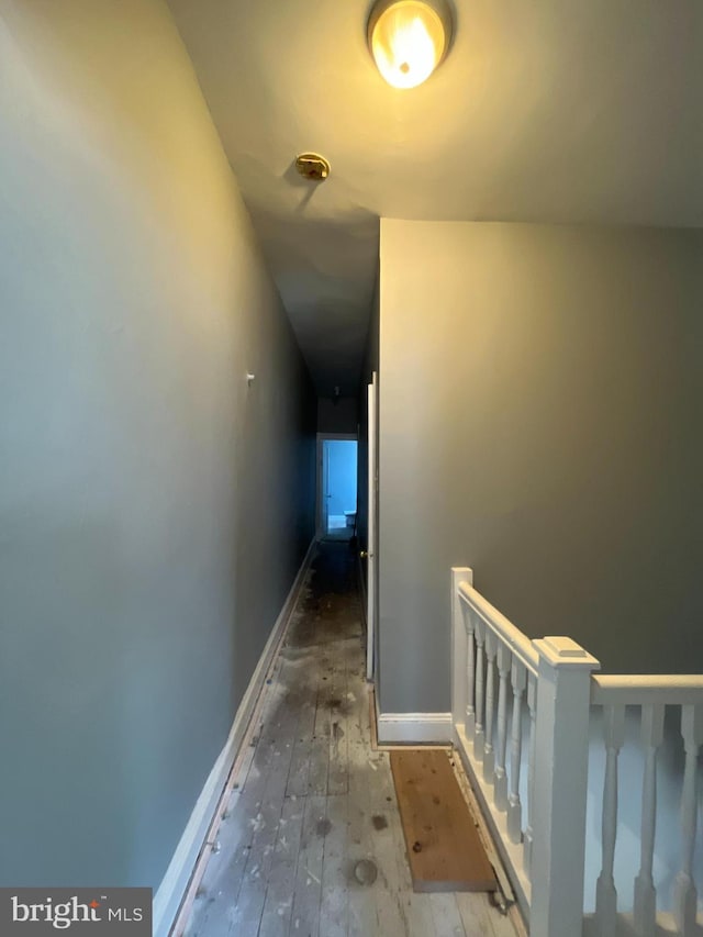 staircase featuring baseboards and wood finished floors