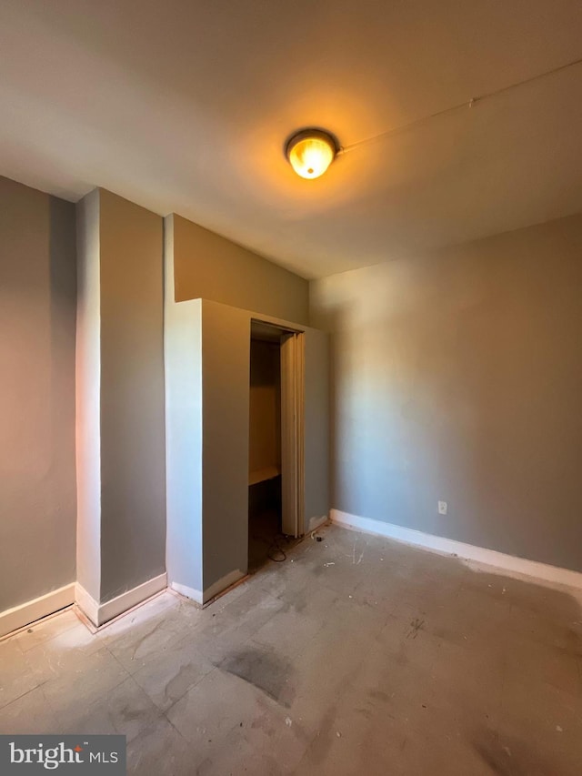 unfurnished bedroom with baseboards and a closet