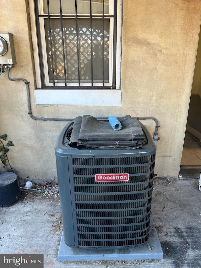 details featuring electric meter, stucco siding, and cooling unit