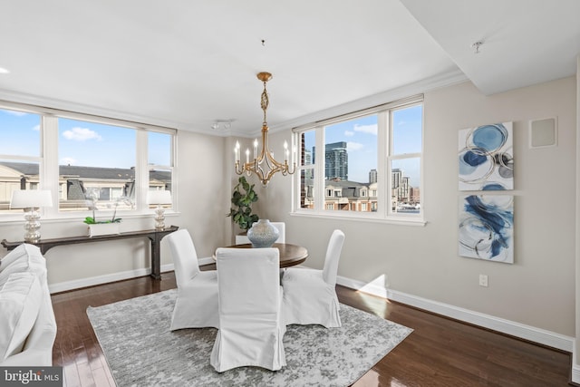 dining space featuring a healthy amount of sunlight, dark wood-style floors, a chandelier, and a city view