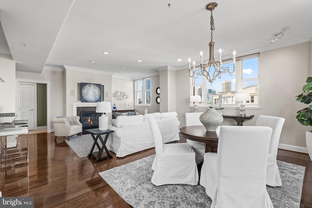 dining space with a view of city, a glass covered fireplace, dark wood finished floors, and crown molding