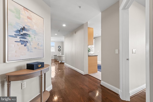 hallway featuring dark wood-style floors, baseboards, and recessed lighting