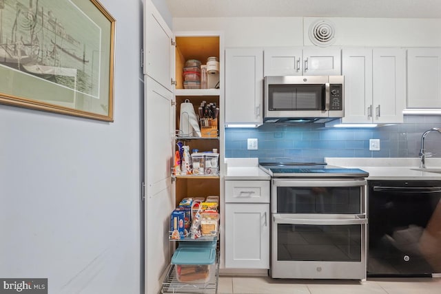 kitchen featuring a sink, stainless steel appliances, light countertops, and white cabinets