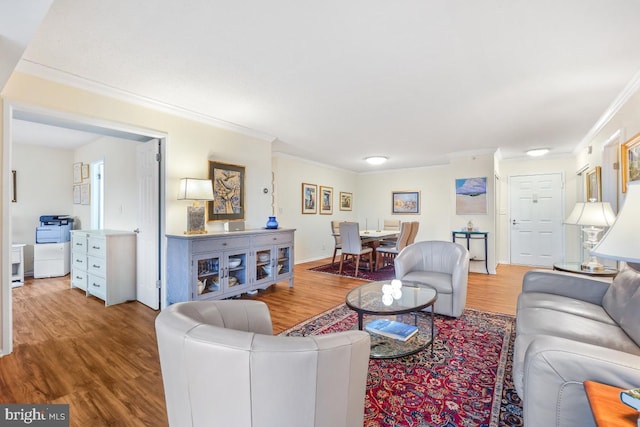 living room with baseboards, wood finished floors, and crown molding