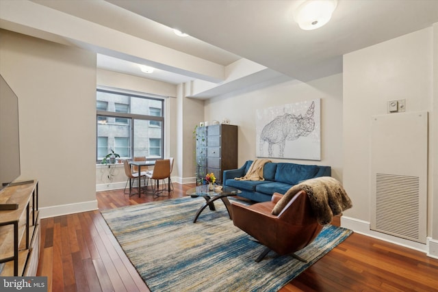 living area featuring visible vents, dark wood finished floors, and baseboards