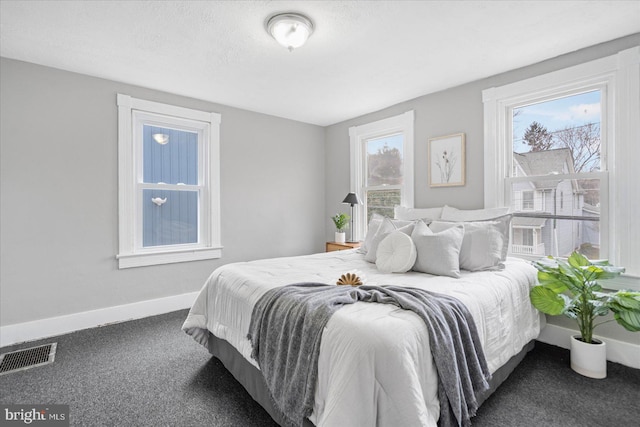 bedroom featuring visible vents, a textured ceiling, baseboards, and carpet flooring