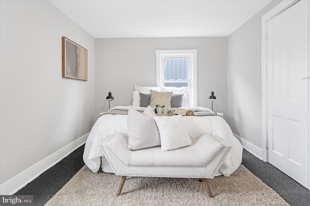 bedroom featuring baseboards and dark carpet