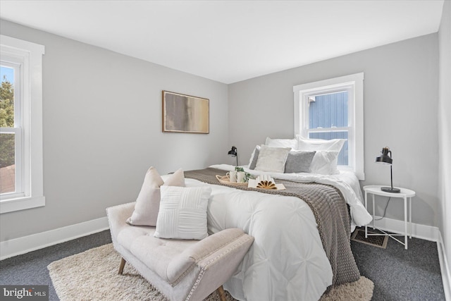 bedroom with dark colored carpet and baseboards