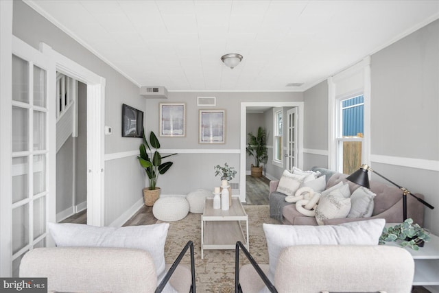 living area with ornamental molding, french doors, wood finished floors, and visible vents