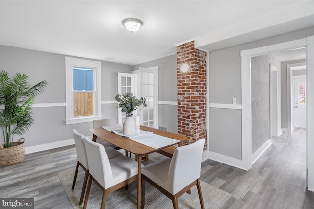 dining area with wood finished floors, a wealth of natural light, and baseboards