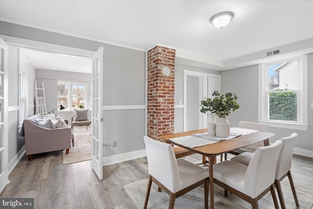 dining area with baseboards, visible vents, and light wood finished floors