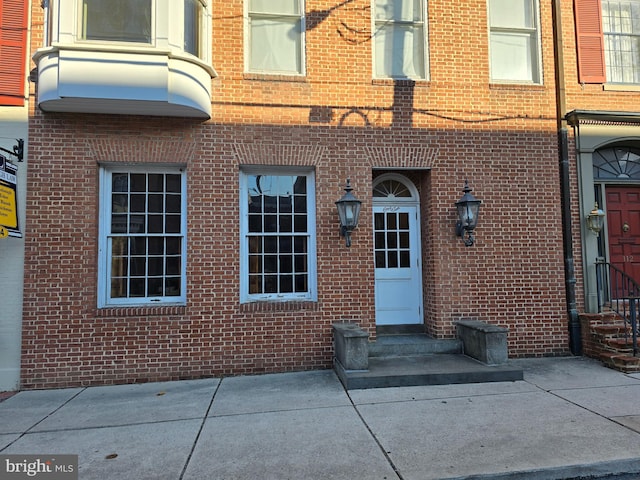 entrance to property featuring brick siding