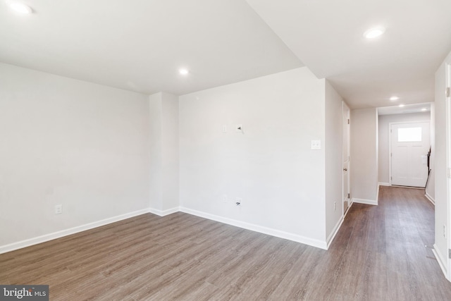 unfurnished room with baseboards, wood finished floors, and recessed lighting