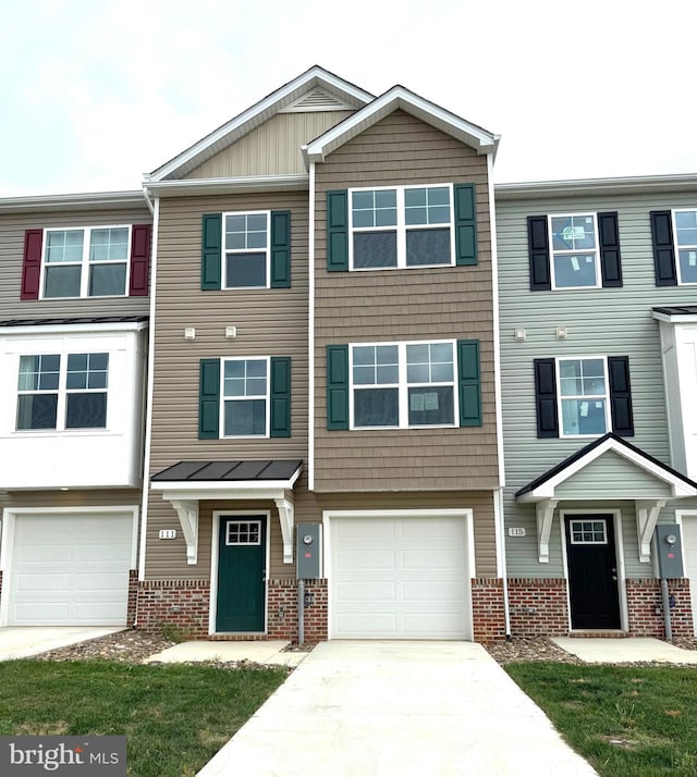 townhome / multi-family property featuring brick siding, board and batten siding, an attached garage, and driveway