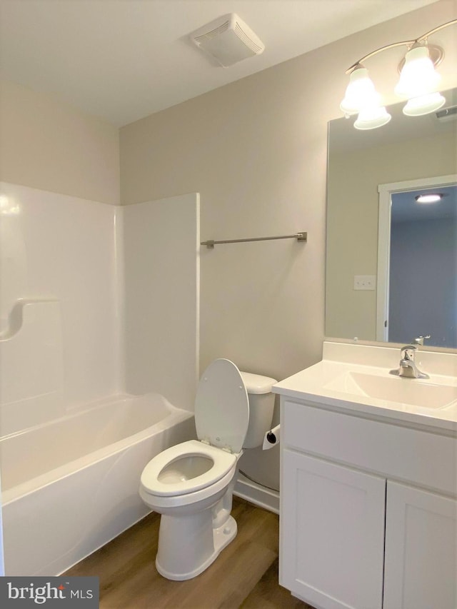 full bath featuring visible vents, shower / bath combination, toilet, vanity, and wood finished floors