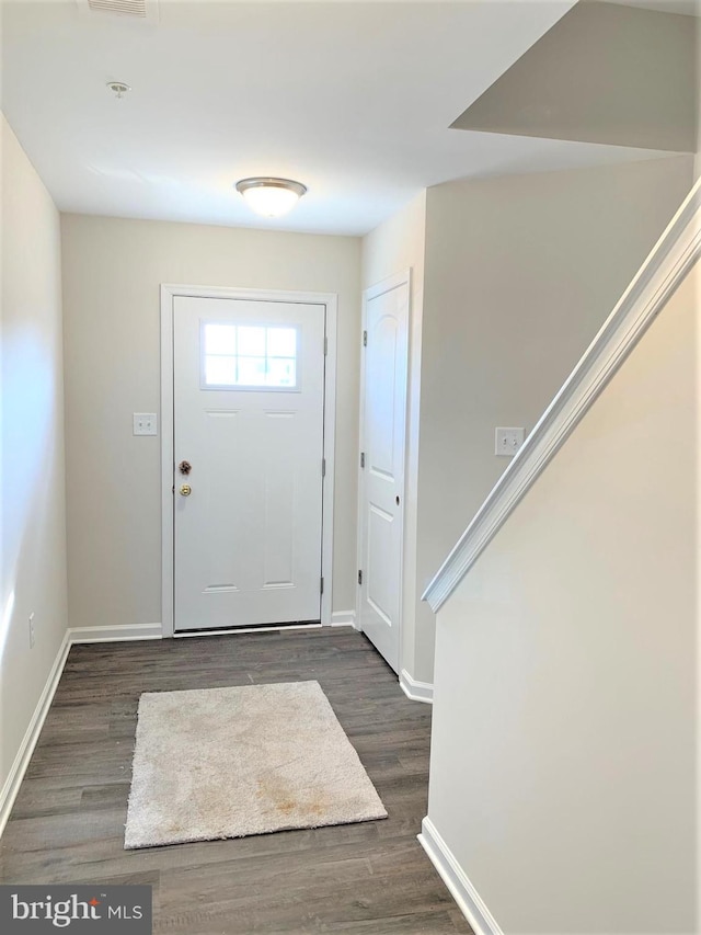 foyer featuring baseboards, visible vents, and dark wood-type flooring