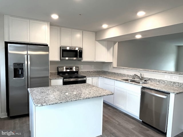 kitchen featuring a sink, a center island, dark wood-type flooring, white cabinets, and stainless steel appliances