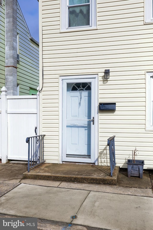 doorway to property featuring fence