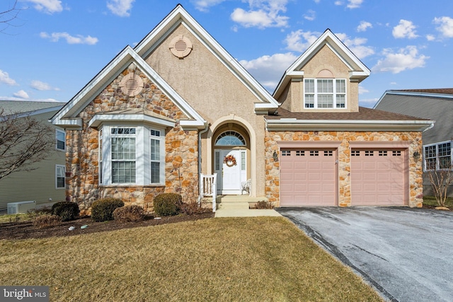 traditional-style house with a garage, stone siding, a front lawn, and aphalt driveway