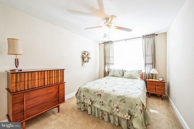 bedroom with ceiling fan, baseboards, and light carpet