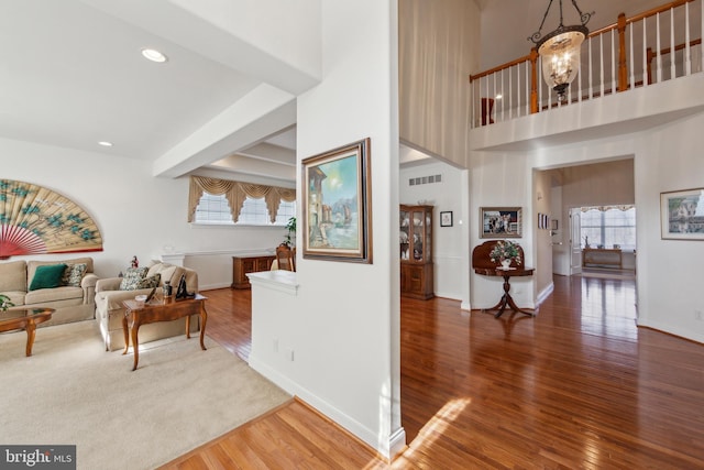 living room with baseboards, a notable chandelier, and wood finished floors