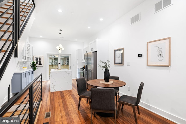 dining room featuring visible vents, recessed lighting, stairway, and wood finished floors