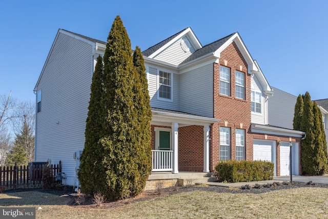 traditional-style home with covered porch, brick siding, a front yard, and fence