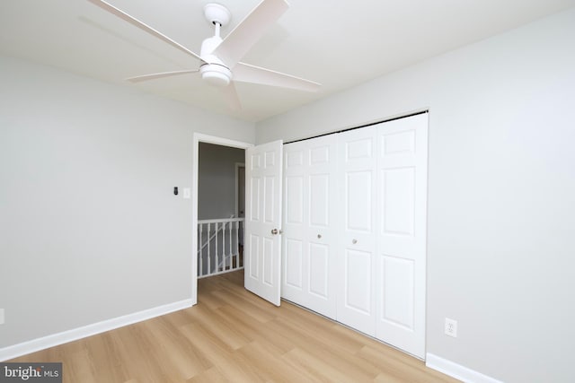 unfurnished bedroom featuring a ceiling fan, a closet, baseboards, and light wood finished floors