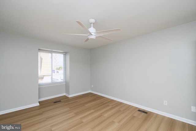 spare room featuring light wood-style flooring, visible vents, and baseboards