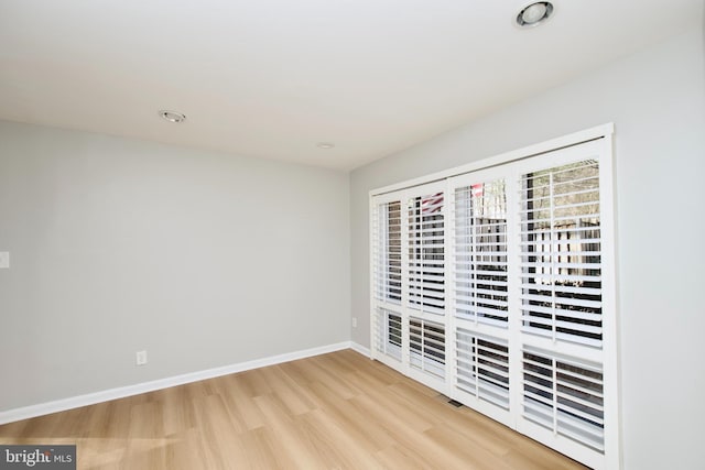 unfurnished room with light wood-style floors and baseboards