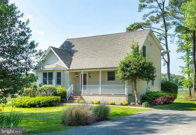 view of front of home with a porch, a front yard, and roof with shingles