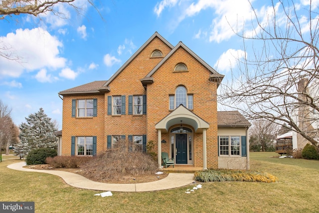 traditional-style home with brick siding and a front yard