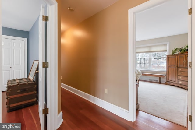 corridor with wood finished floors, visible vents, and baseboards