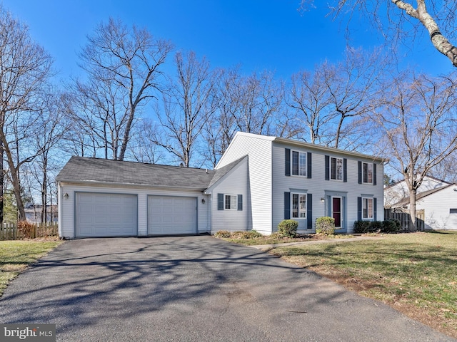 colonial inspired home featuring a front yard, driveway, and an attached garage