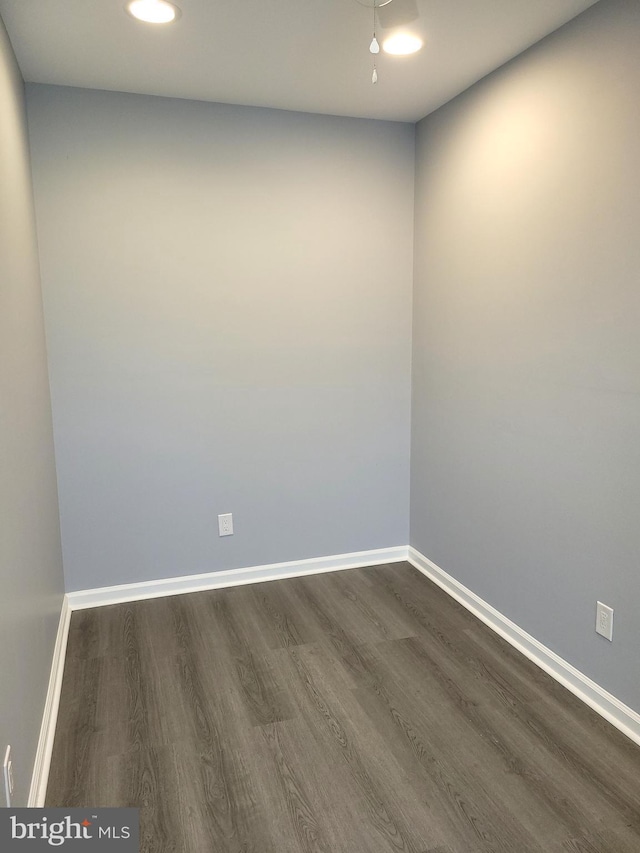 empty room with dark wood finished floors and baseboards