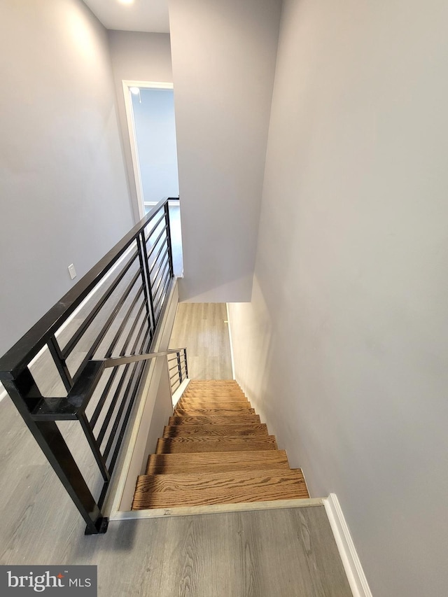 staircase with wood finished floors and baseboards