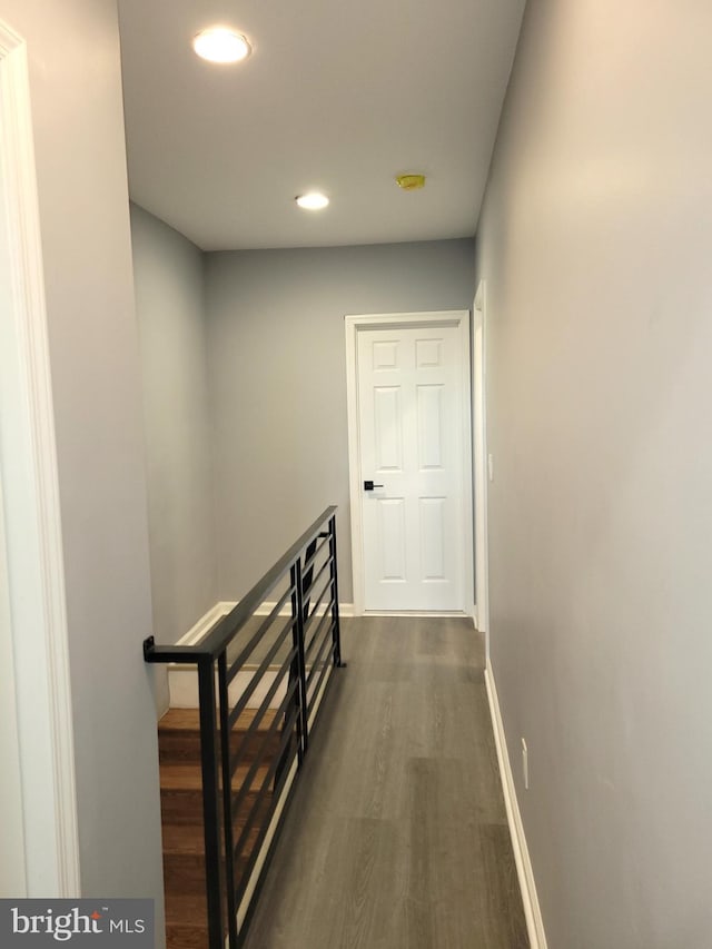 hall featuring dark wood-style floors, recessed lighting, an upstairs landing, and baseboards