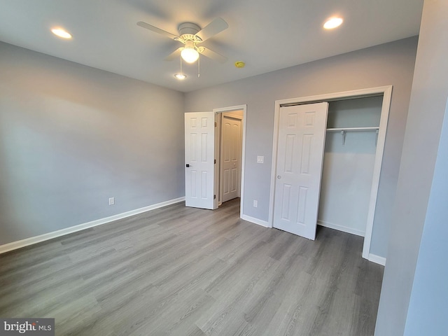 unfurnished bedroom featuring recessed lighting, a closet, a ceiling fan, wood finished floors, and baseboards