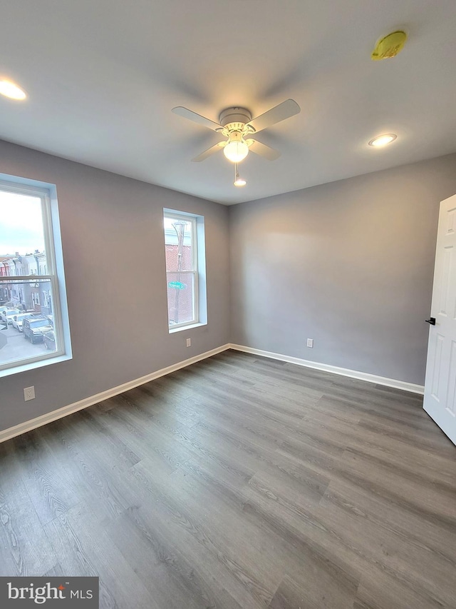 empty room with baseboards, dark wood finished floors, a ceiling fan, and recessed lighting