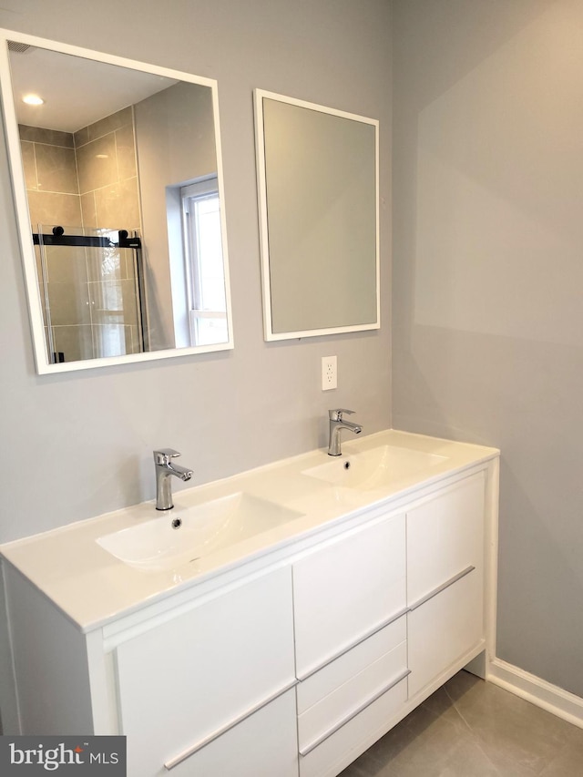 full bathroom with double vanity, tile patterned floors, a sink, and tiled shower