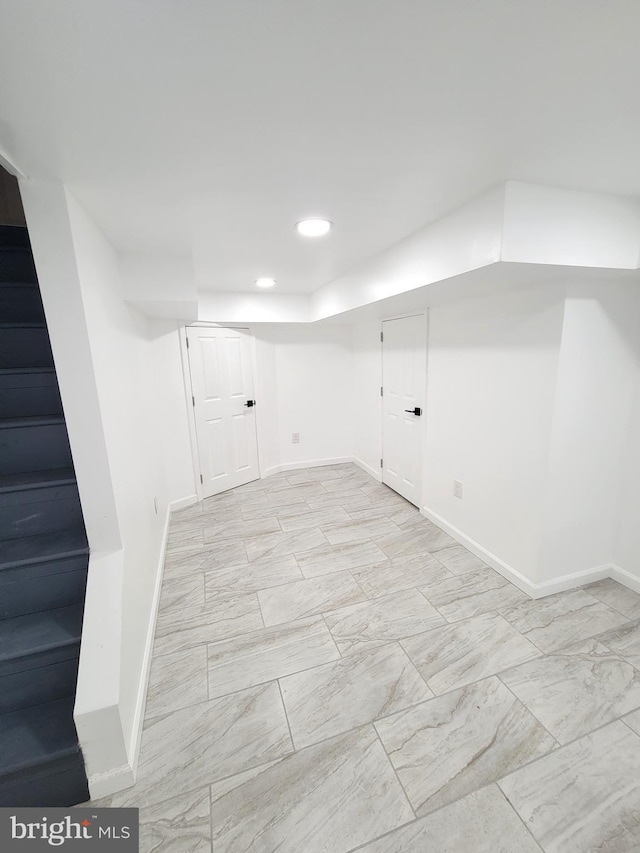 finished basement with recessed lighting, marble finish floor, and baseboards