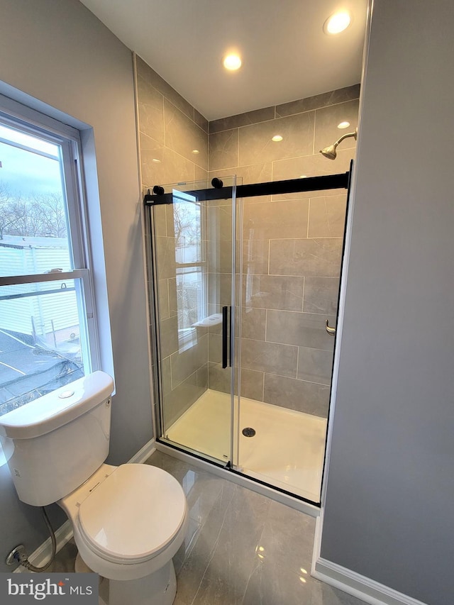 full bathroom with a stall shower, baseboards, toilet, and recessed lighting