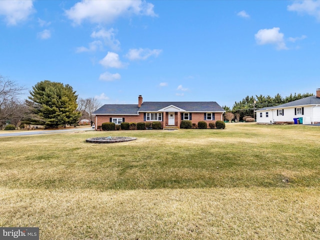 single story home with brick siding, a chimney, and a front lawn