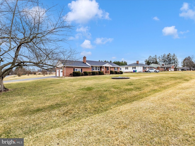 view of yard with an attached garage, driveway, and a residential view