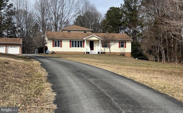 ranch-style house featuring entry steps, an outbuilding, and a front lawn