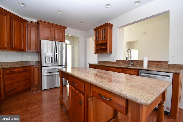 kitchen with open shelves, dark wood-type flooring, light stone countertops, appliances with stainless steel finishes, and a sink