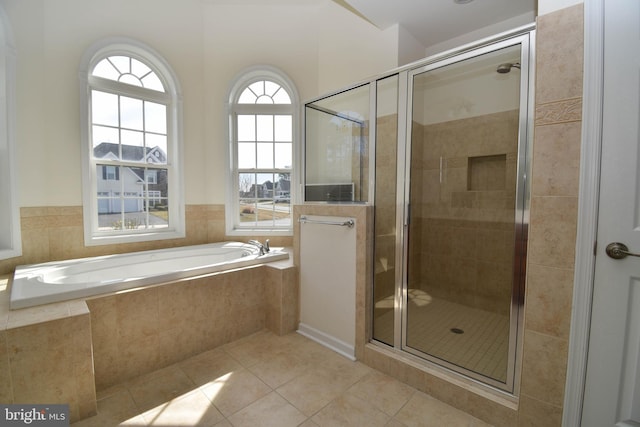 full bath featuring tile patterned flooring, a bath, and a stall shower